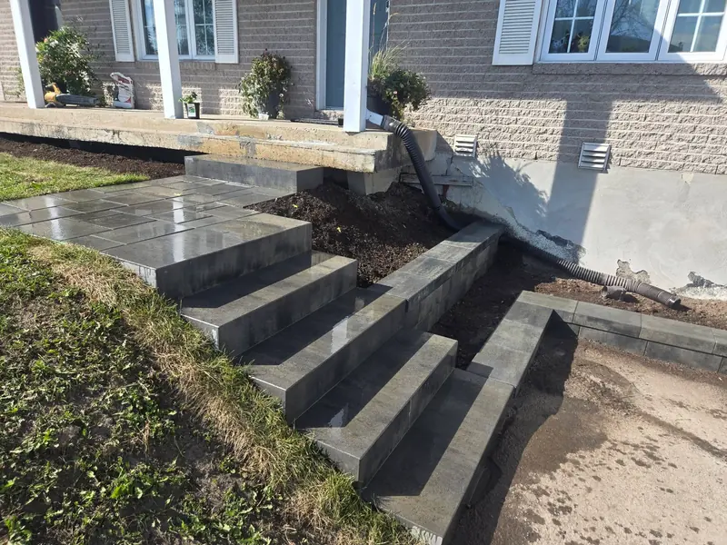 Paliers, marches et bordures en pavés devant une maison jumelée